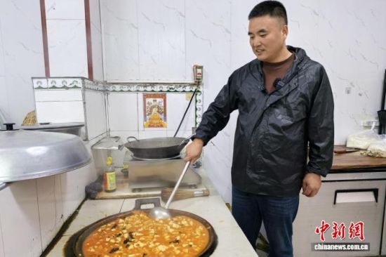 图为庞富强在自家厨房为留守老人做饭。 梅镱泷 摄 图为庞富强在自家厨房为留守老人做饭。 梅镱泷 摄