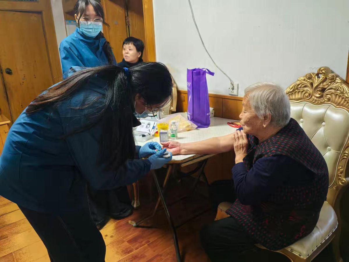 医护人员为老人测血糖。 医护人员为老人测血糖。