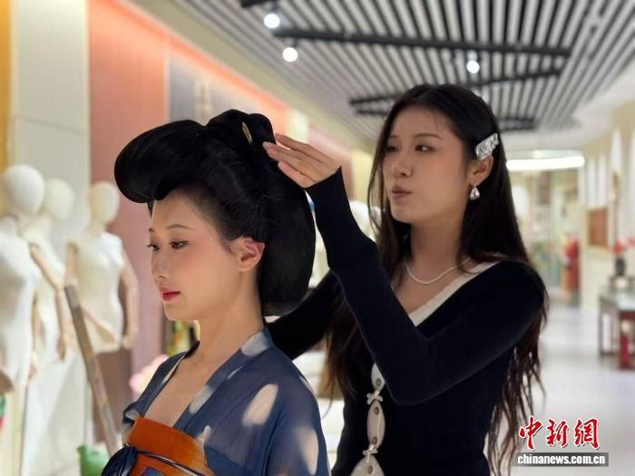 图为王依婷(右)正在整理发髻。 杨英琦 摄 图为王依婷(右)正在整理发髻。 杨英琦 摄