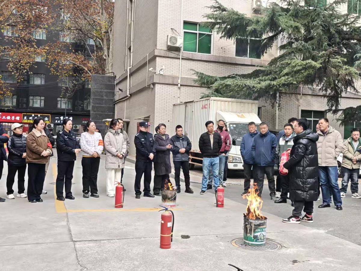 工作人员教居民灭火器的使用步骤。 工作人员教居民灭火器的使用步骤。