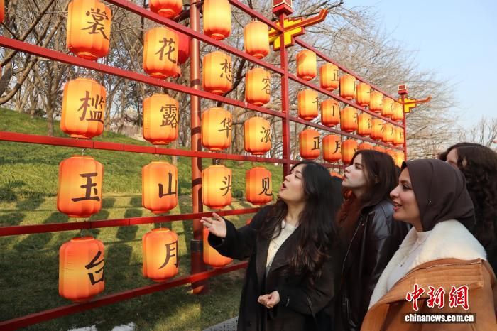 1月22日,外籍友人在西安大唐芙蓉园“唐诗灯组”前朗诵唐诗。 李一璠 摄 1月22日,外籍友人在西安大唐芙蓉园“唐诗灯组”前朗诵唐诗。 李一璠 摄