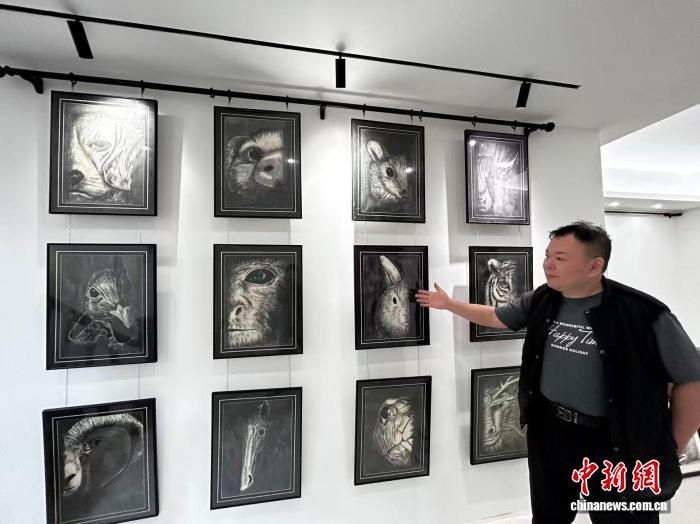 图为台胞李永星介绍自己创作的十二生肖画作。 中新网记者 符宇群 摄 图为台胞李永星介绍自己创作的十二生肖画作。 中新网记者 符宇群 摄