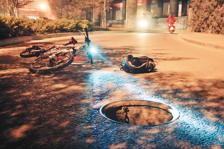 无盖井旁躺着自行车:摆拍图片提醒路人注意-中国新闻网-陕西新闻